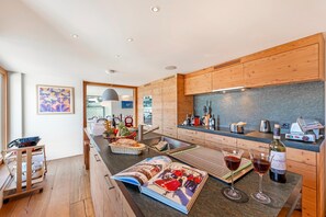 Eine moderne Küche mit Holzausstattung, einer Arbeitsplatte aus Granit und einer auf der Theke liegenden Zeitschrift.