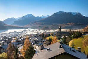 Eine Stadt mit einer markanten Kirche, einem See und Bergen im Hintergrund.