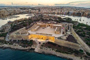 An aerial view of a historic fortified city with a prominent central square, surrounding walls, and a harbor filled with boats. - Modern Penthouse Savoy Garden in Gzira (Gzira)