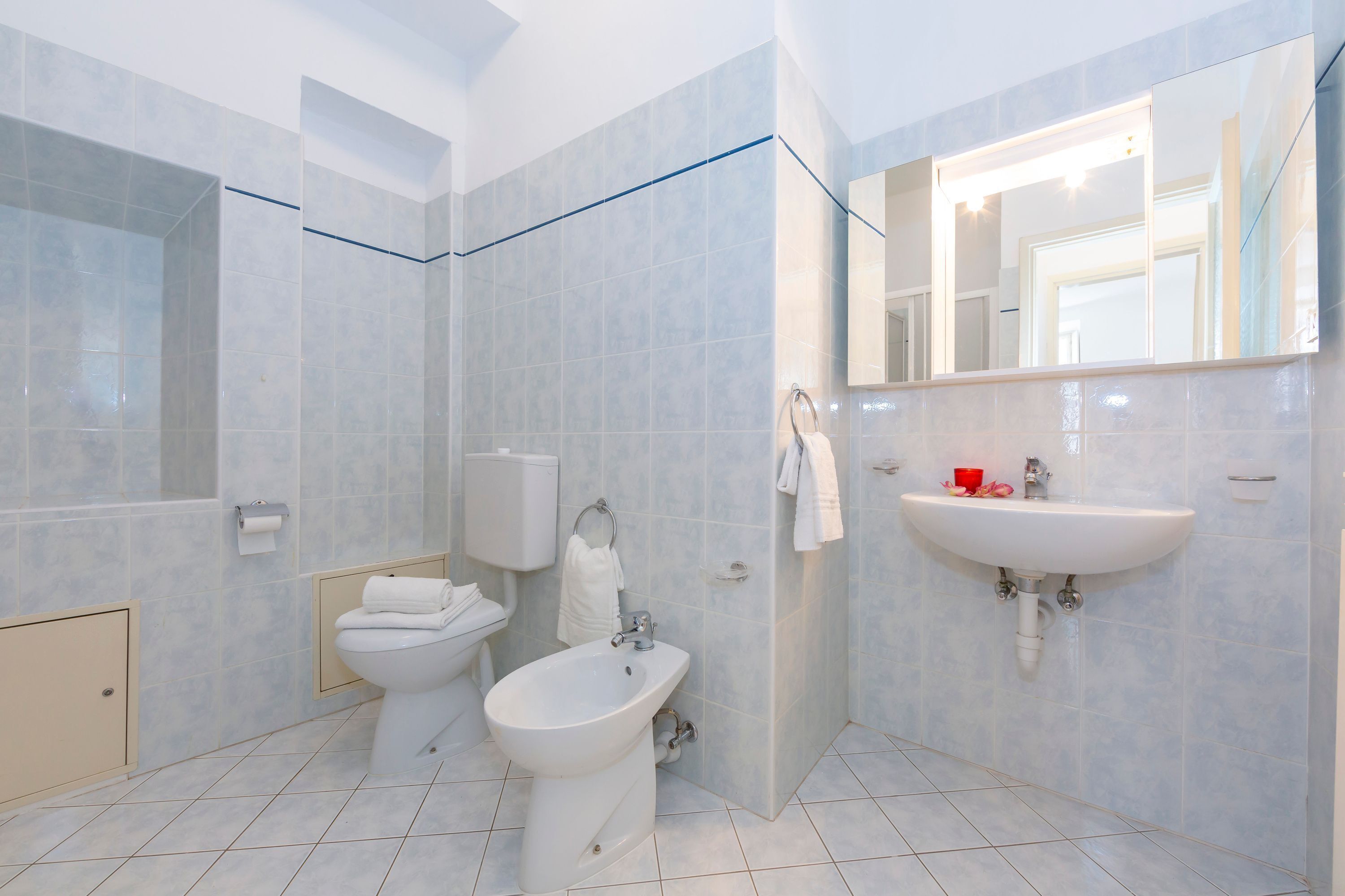 A modern bathroom with a toilet, bidet, and sink.