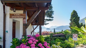 A building labeled "Cori Apartments" with a view of mountains and a lake. - CO RI Appartamenti 1 (Menaggio)