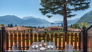 A terrace with a table set for two, overlooking a lake and mountains. - CO RI Appartamenti 1 (Menaggio)
