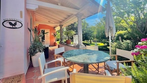 An outdoor patio with a round table and chairs, a 'Bienvenue' sign, and potted plants. - Villa Alice in Menaggio (Menaggio)