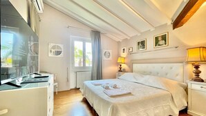 A neatly arranged bedroom with a bed, bedside tables, a desk, and a window. - Villa Alice in Menaggio (Menaggio)