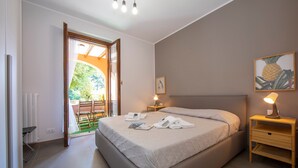 A bedroom with a bed, a nightstand, a lamp, and a painting of a pineapple. - Menaggio Palphi in Menaggio (Menaggio)