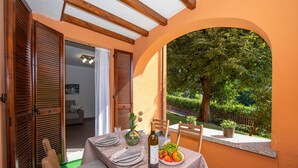An outdoor dining area with a table set for two, a bottle of wine, and a bowl of fruit. - Menaggio Palphi in Menaggio (Menaggio)