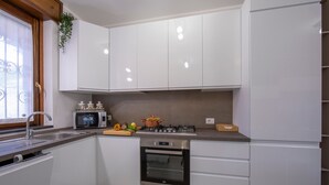 A modern kitchen with white cabinets, a built-in oven, a microwave, and a gas stove. - Menaggio Palphi in Menaggio (Menaggio)