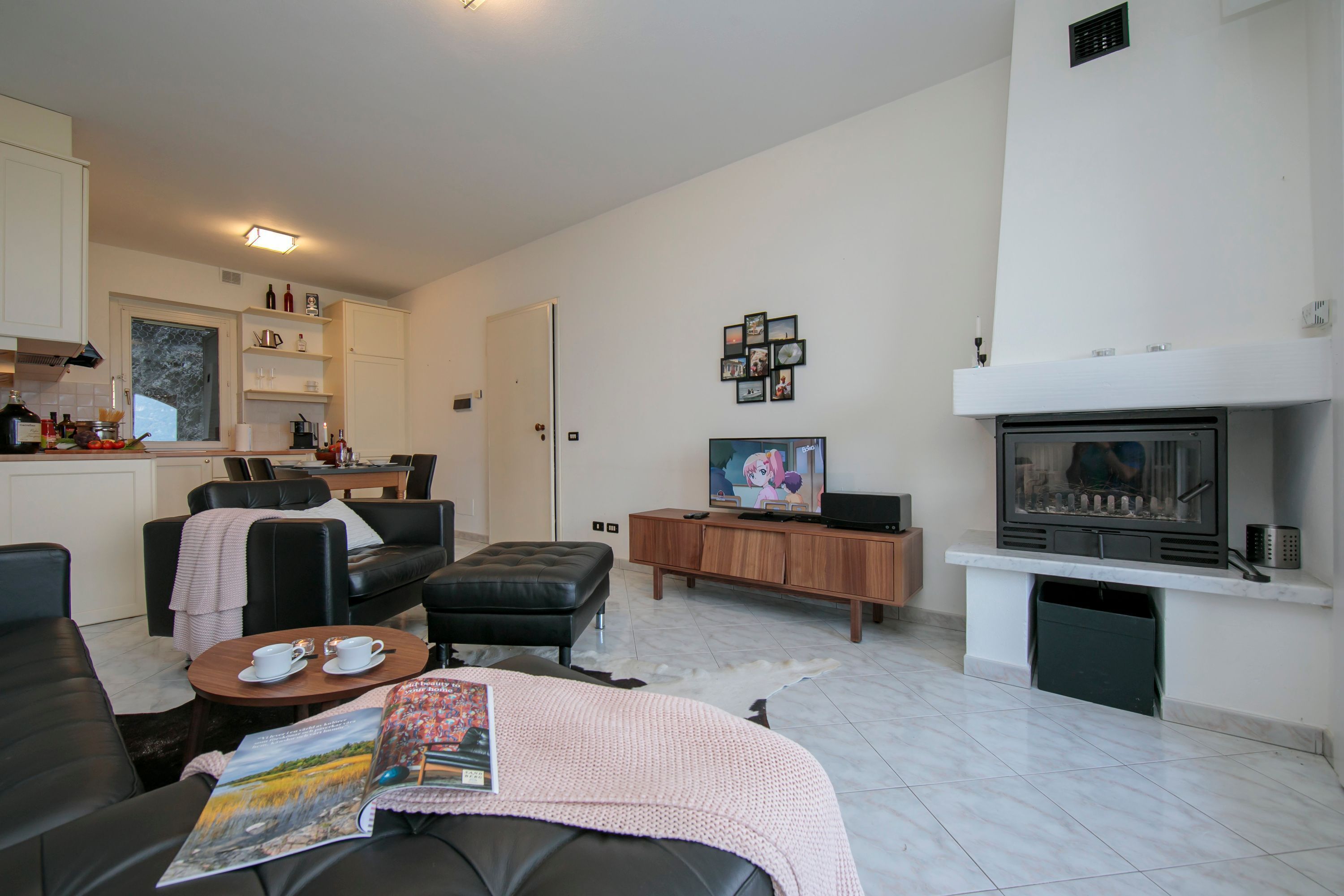 Una sala moderna con chimenea, televisor y comedor.