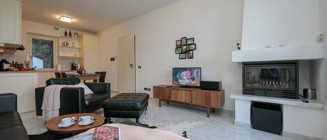 Una sala moderna con chimenea, televisor y comedor.