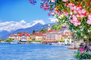 A waterfront hotel with multiple buildings, a bell tower, and boats on the water. - CO RI Appartamenti Dependance (Menaggio)