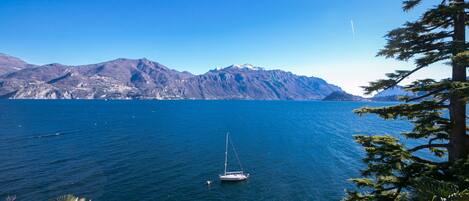A sailboat on calm waters with mountains in the background.