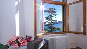 Ein Zimmer mit Blick auf einen Baum und ein Gewässer.