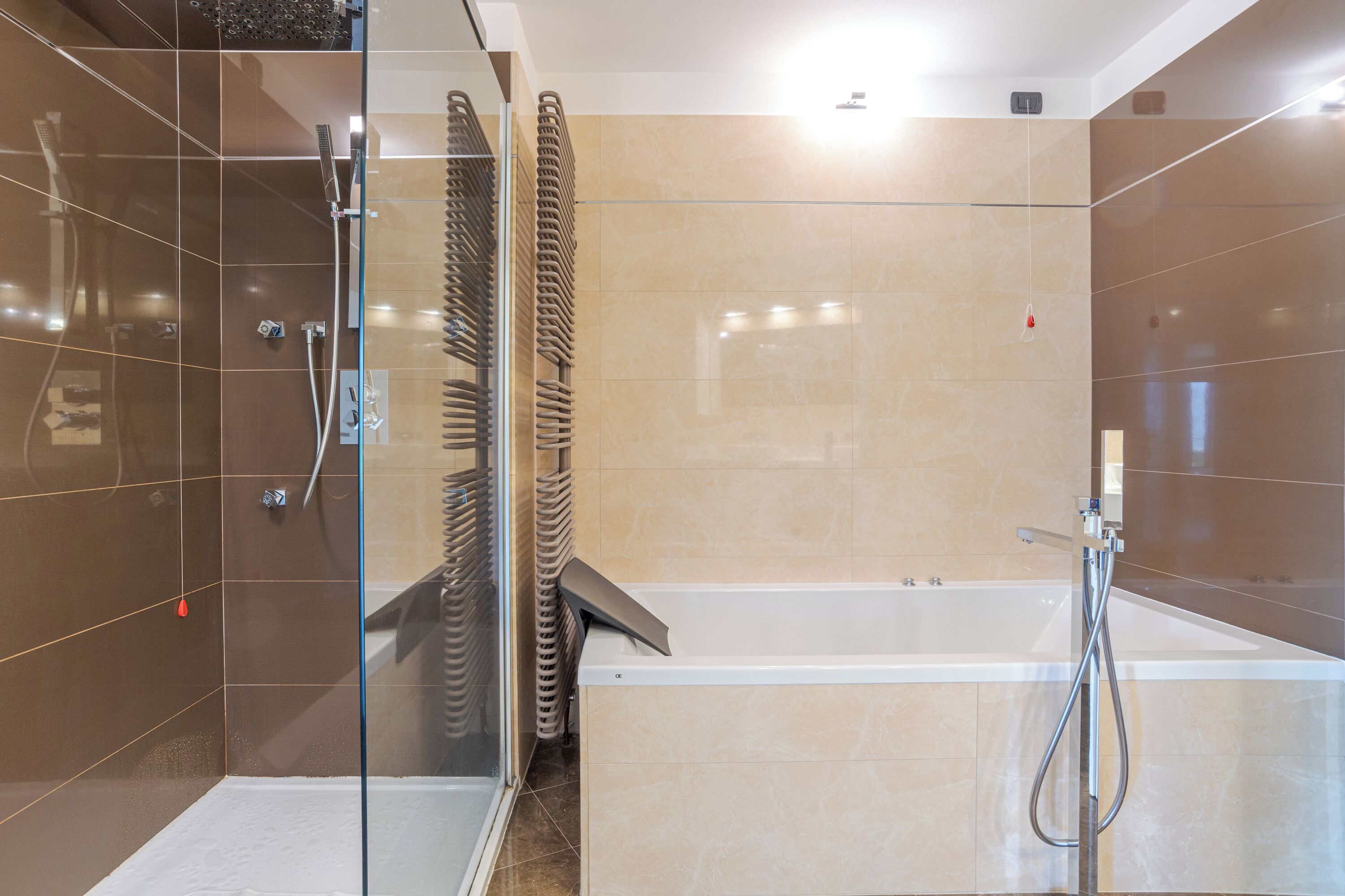 Un bagno moderno con doccia vetro, vasca e porta in vetro.