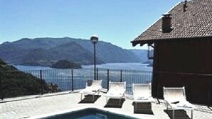 Piscina con sillas de descanso y vistas a las montañas.