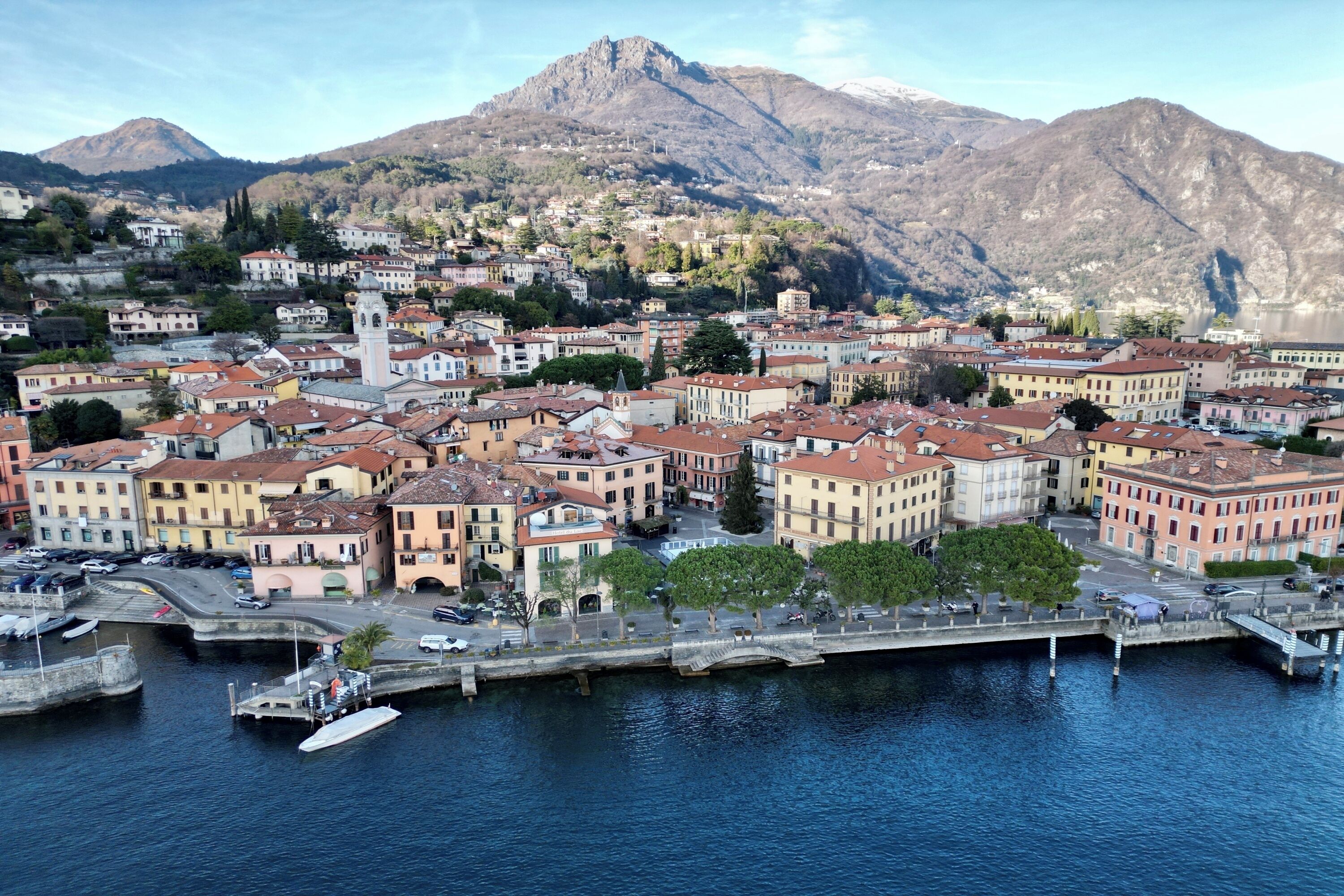 A coastal town with historic buildings, a prominent church tower, and a marina.