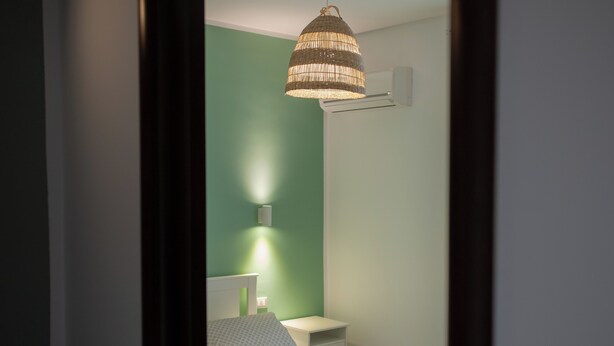 A bedroom with a bed, bedside table, and a hanging lamp. - "Cozy Central Apartment, Near the Sea - Ideal for Holidays" (Balestrate)