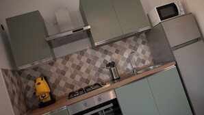 A compact kitchen with a gas stove, microwave, and stainless steel refrigerator. - "Cozy Central Apartment, Near the Sea - Ideal for Holidays" (Balestrate)