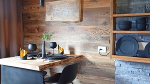Un tavolo da pranzo in legno con stoviglie e una sedia neri.