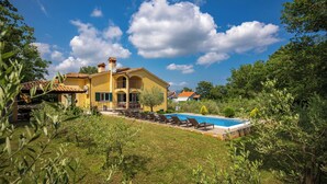 A yellow villa with a swimming pool, surrounded by greenery and a clear blue sky. - 4 BDR Villa Filleona With Pool (Labin)