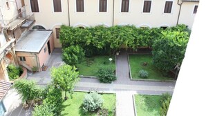 A courtyard with a building featuring multiple windows and a tiled roof. - Appartamento di Yan  (Rome)