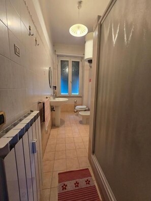 Chambre triple de base, côté cour intérieure | Salle de bain | Douche, séchoir à cheveux, savon, shampooing