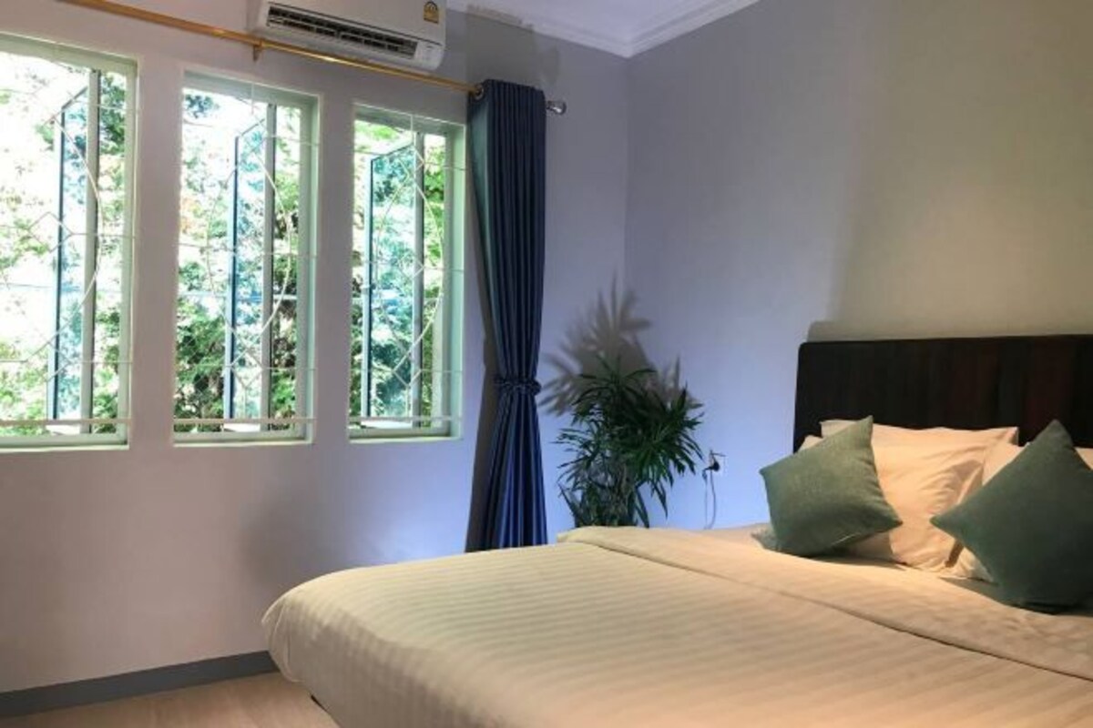 Une chambre à coucher avec un lit, une fenêtre et une plante en pot.