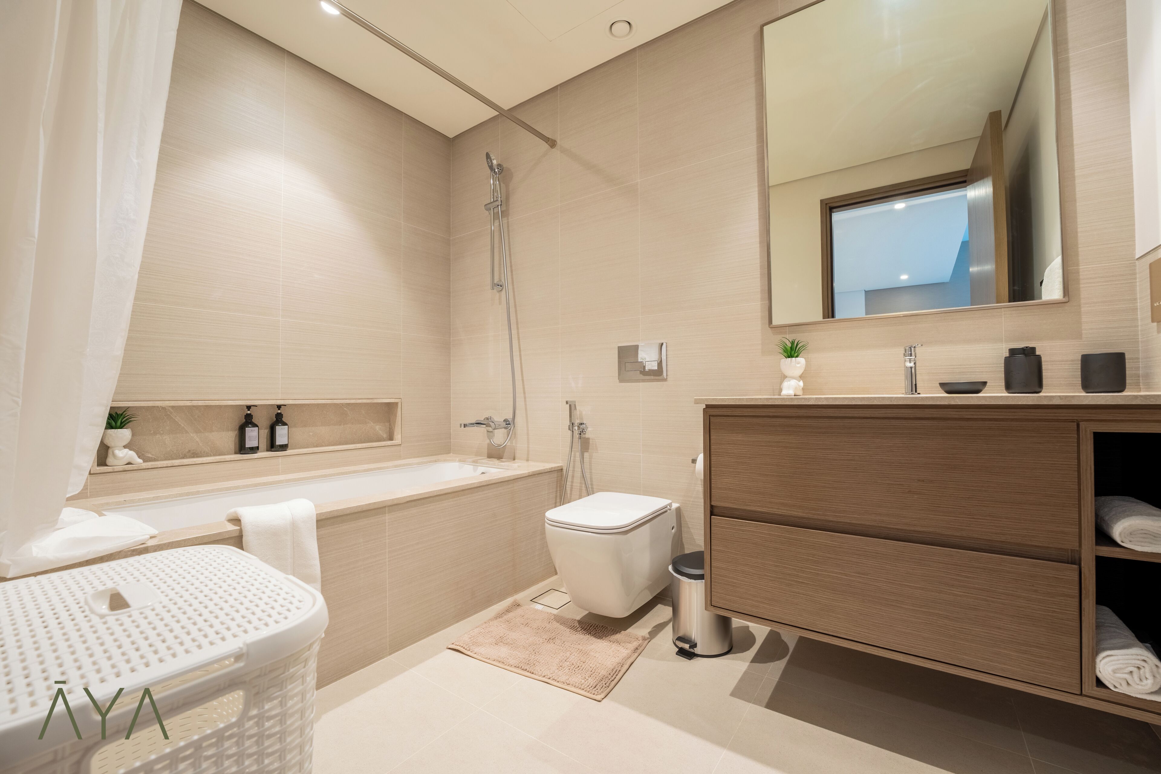 Een moderne badkamer met een bad, toilet en wastafel.