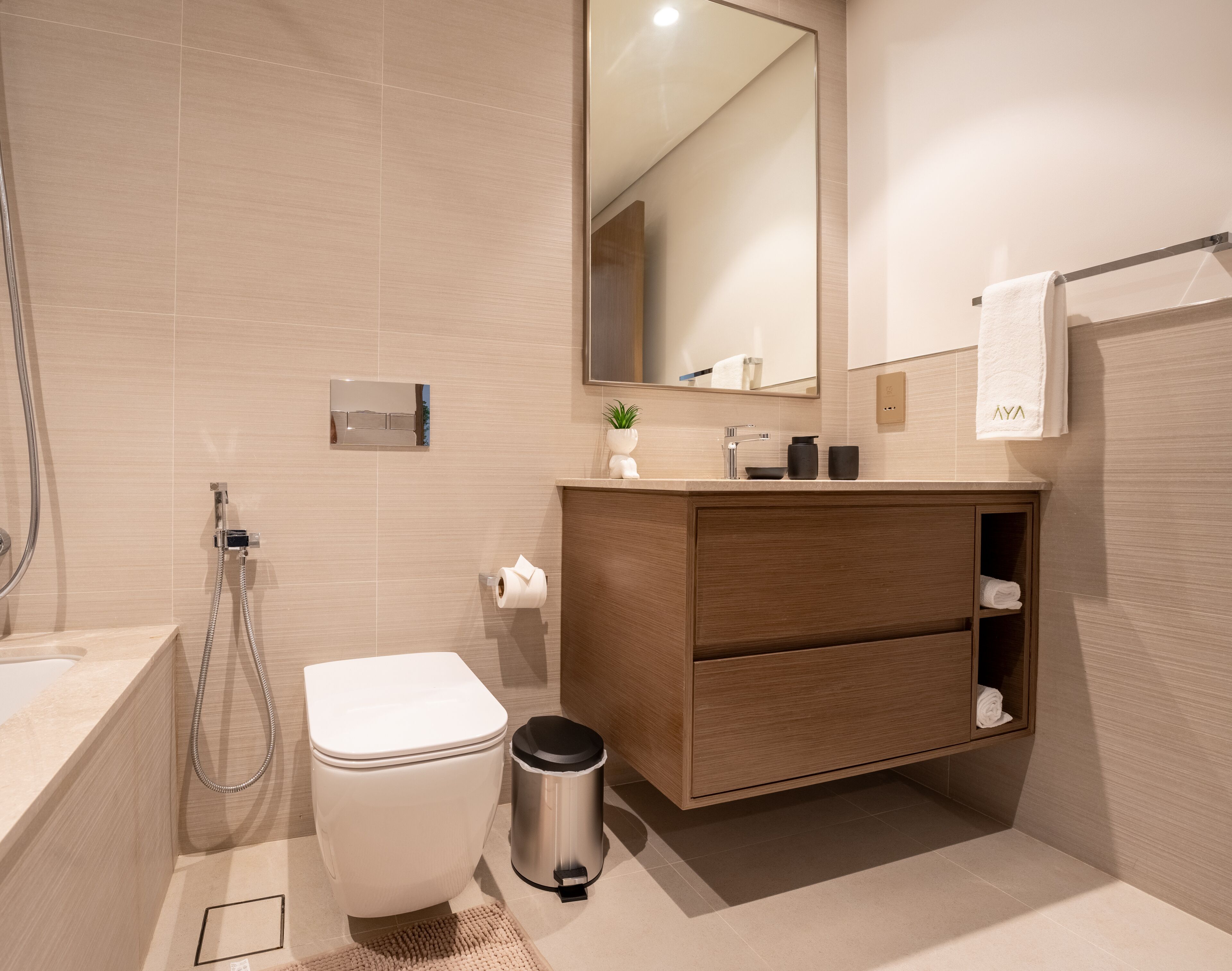 Ein modernes Badezimmer mit Toilette, Bidet, Waschtisch mit Spiegel und Handtuchhalter.