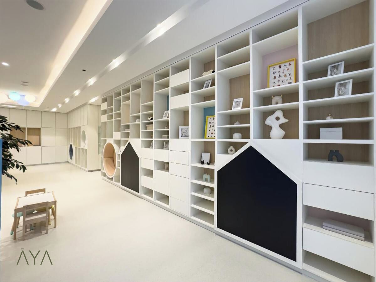 Ein modernes Interieur mit weißen Regaleinheiten, einem kleinen Tisch und einer Pflanze.