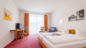 A hotel room with a bed, desk, chair, and a television.