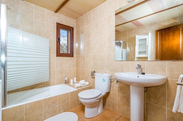 Une salle de bain avec une baignoire, des toilettes et un lavabo.