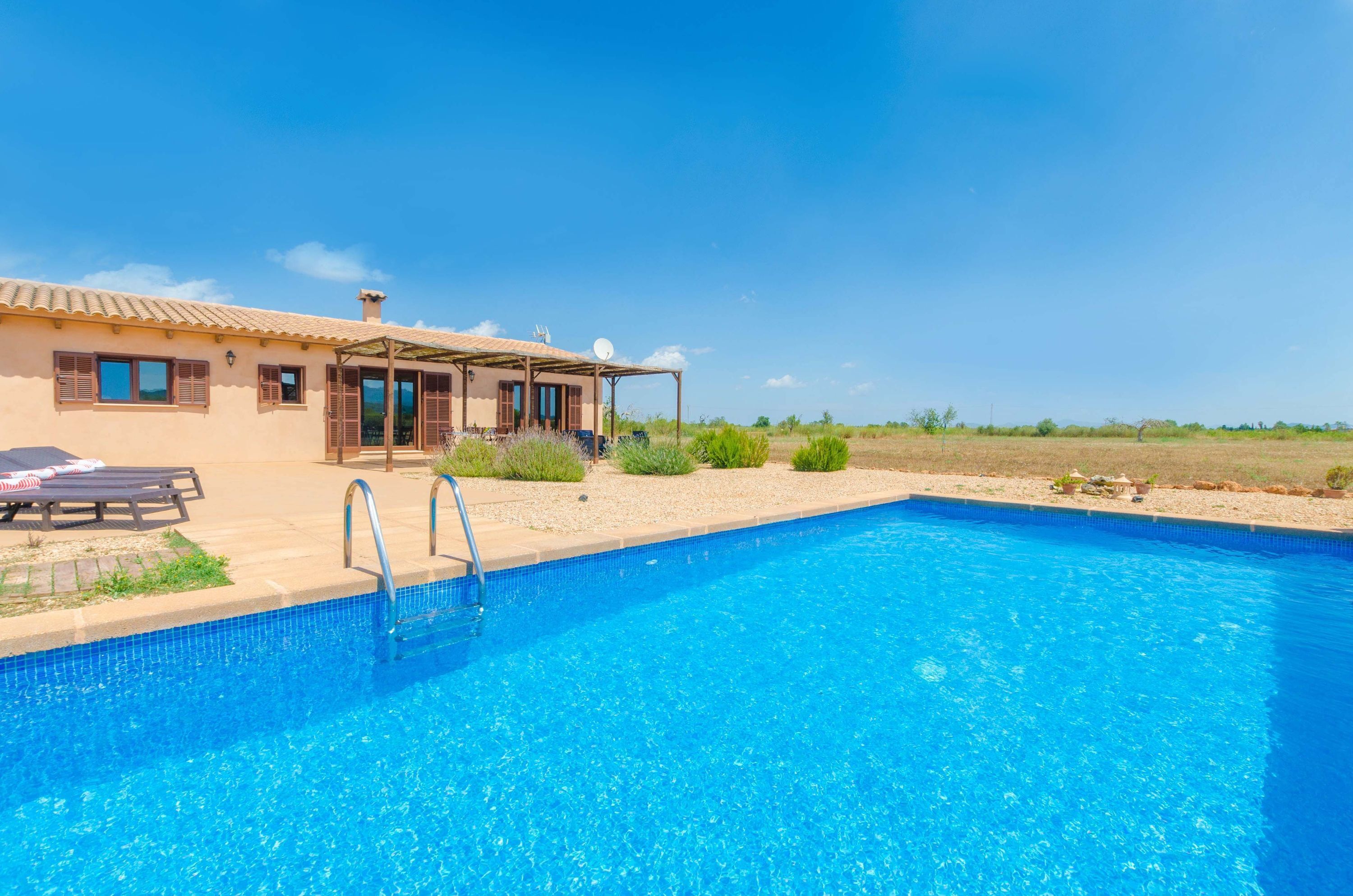 Una piscina con una casa al fondo.