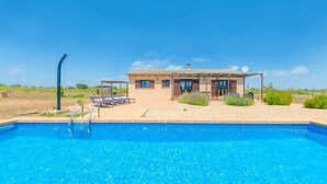 Vista della piscina di una casa con piscina, patio coperto e parabola satellitare.