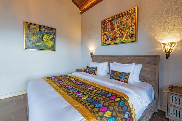 Une chambre d’hôtel avec un grand lit, une tête de lit en bois et deux lampes fixées au mur.