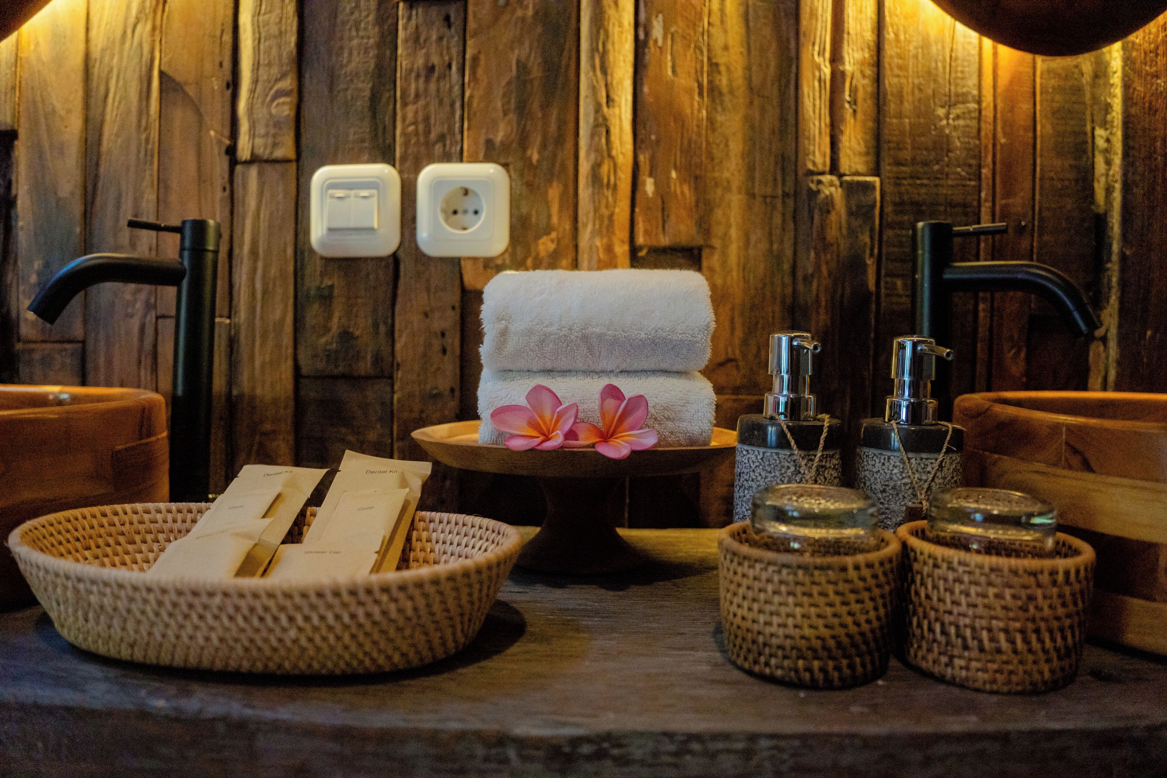 A wooden spa area with a towel, a flower, and toiletries.