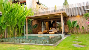 Eine moderne Villa mit Pool, Holzterrasse und üppigem Grün.