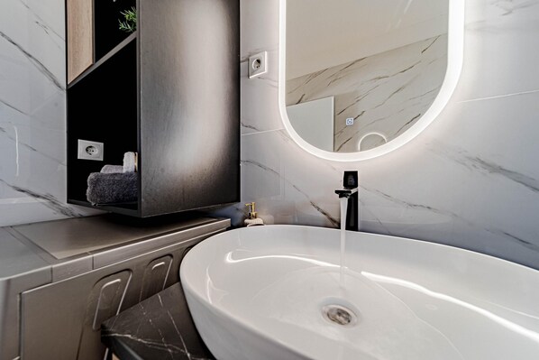 A modern bathroom with a white sink, a mirror, and a built-in shelf. - Villa Antea in Vela Luka (Vela Luka)
