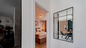 A modern hotel room with a bed, a desk, and a dining area with chairs and a table. - Villa Antea in Vela Luka (Vela Luka)