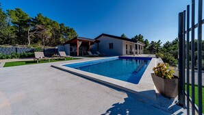 A modern house with a swimming pool, lounge chairs, and a covered patio. - Villa Antea in Vela Luka (Vela Luka)