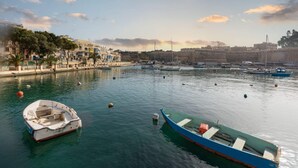 A harbor with boats, a fort, and buildings along the waterfront. - Marina View - Front of Sea Cospicua (Cospicua)