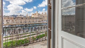 A view from a balcony overlooking a historic building with a river and boats. - Marina View - Front of Sea Cospicua (Cospicua)