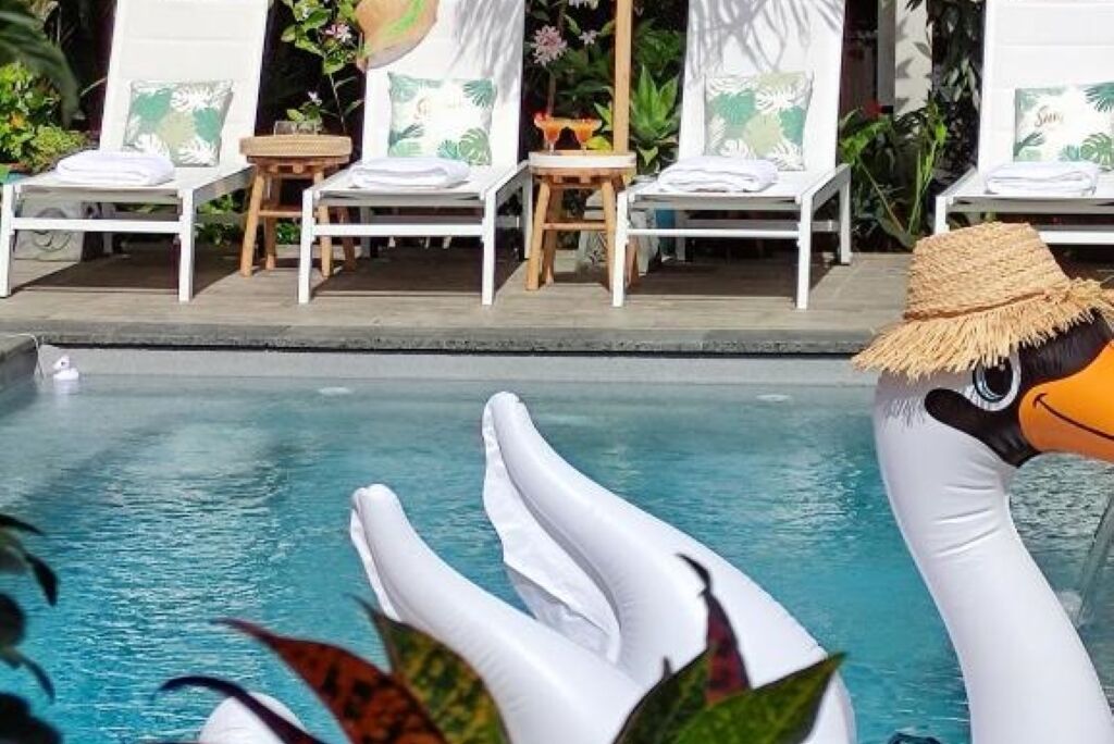 A pool area with lounge chairs and a decorative flamingo float.