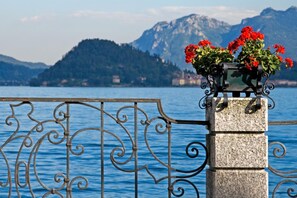 A stone pillar with a metal railing and a flower vase. - Casa Daniele in Menaggio (Menaggio)