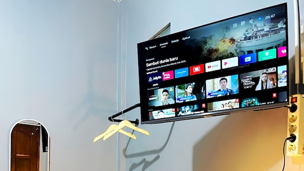 A modern room with a flat-screen TV mounted on the wall displaying various streaming services. - JOGJA DAY INN (Yogyakarta)