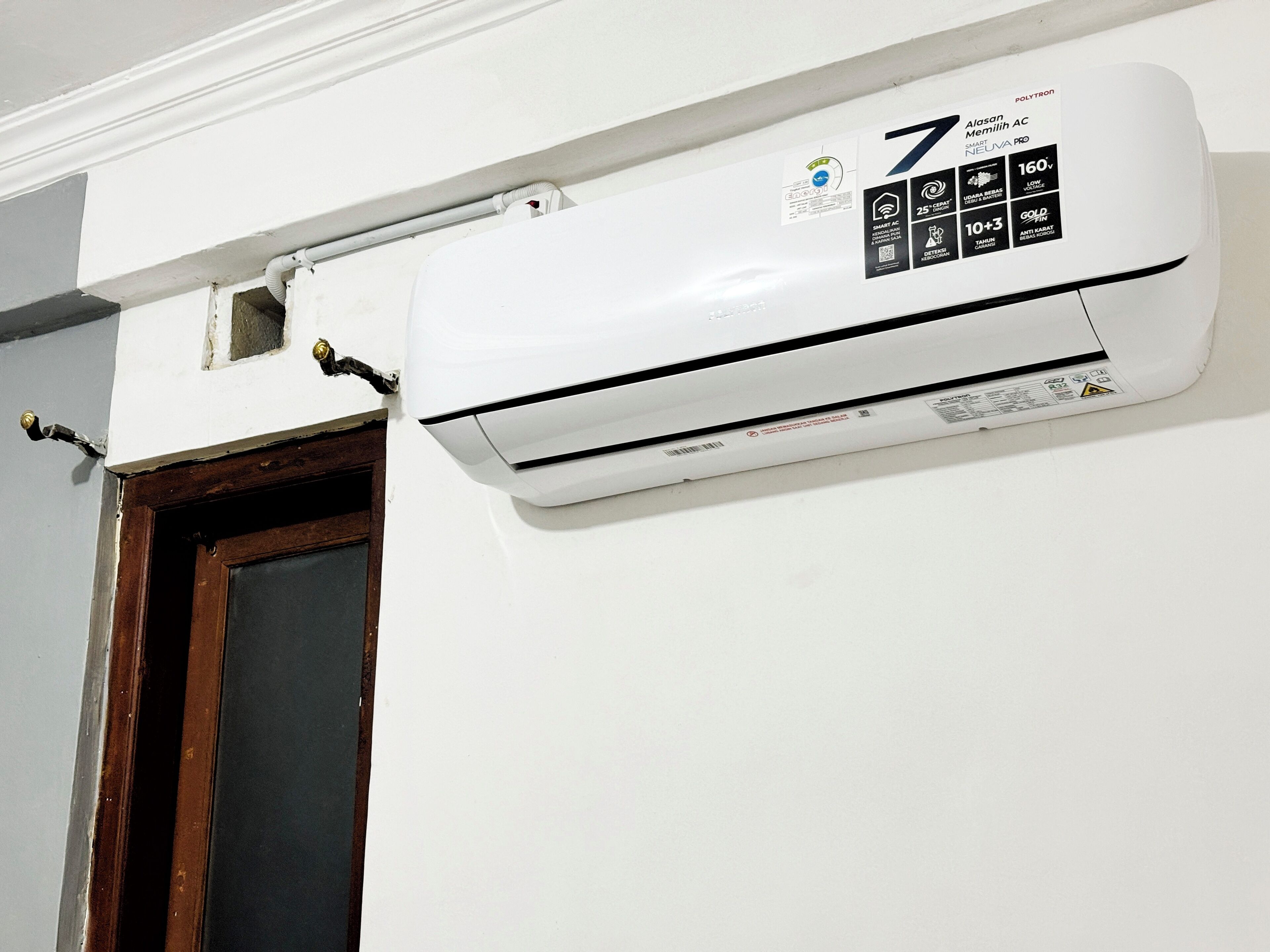 A white wall-mounted air conditioner with a control panel and a label indicating it is a smart AC unit.
