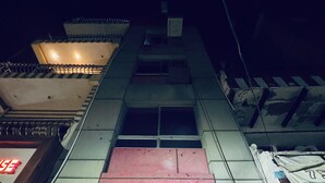 A multi-story building with a red awning and a visible entrance. - Suraj Guest House (Varanasi)