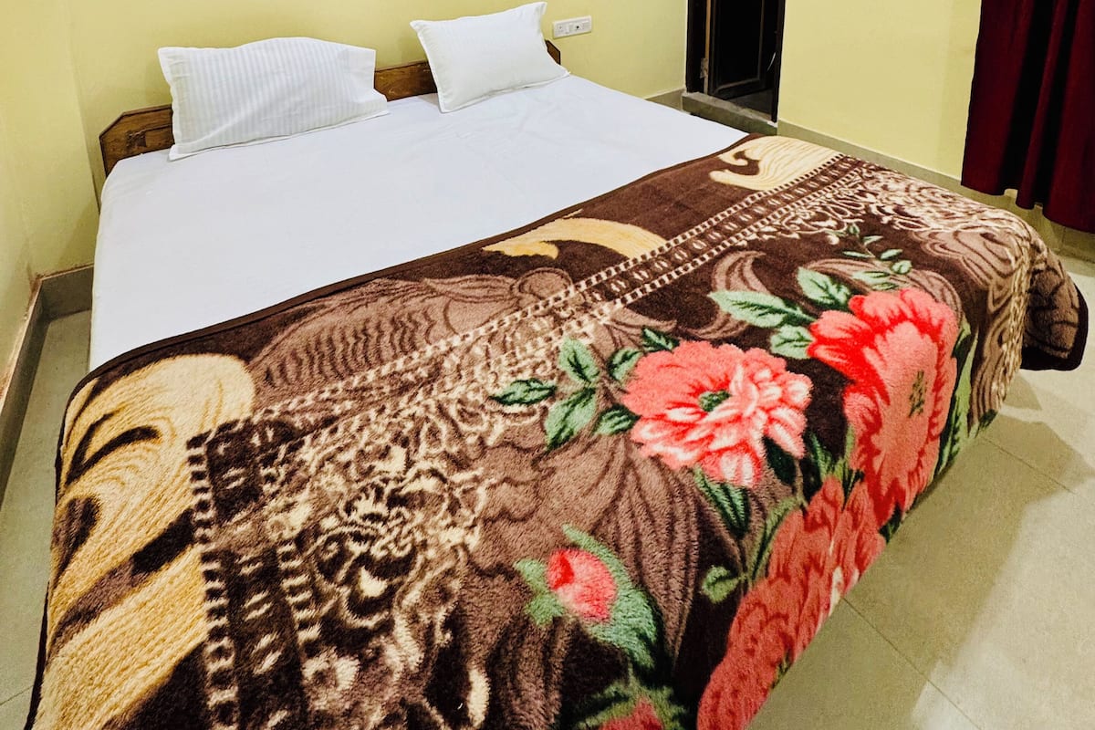 Una habitación de hotel con una cama, un televisor de pantalla plana y una puerta.