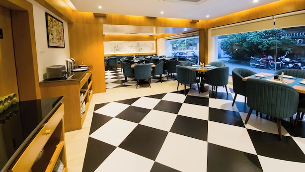 Ein Restaurant mit Schachbrettboden, Holzwänden und Blick auf die Straße durch große Fenster.