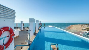 Un espace piscine offrant une vue sur la plage et l’océan.