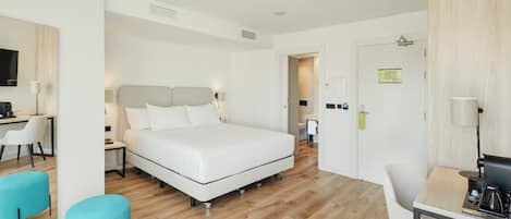 Una habitación de hotel moderna con una cama, un escritorio y una silla.